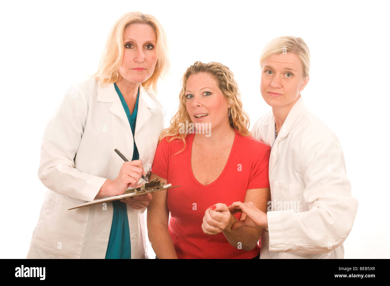 Trois infirmières urse équipe groupe dame dames femmes d'équipe assez patient test de pression du sang bureau hôpital lire aide lecture o Banque D'Images