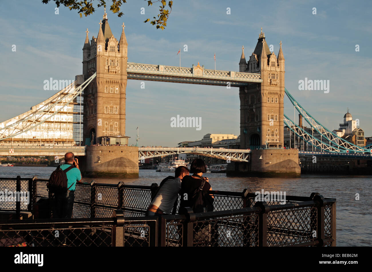 Trois touristes passent une soirée d'été, Tower Bridge sur la Tamise à Londres, Royaume-Uni. Banque D'Images