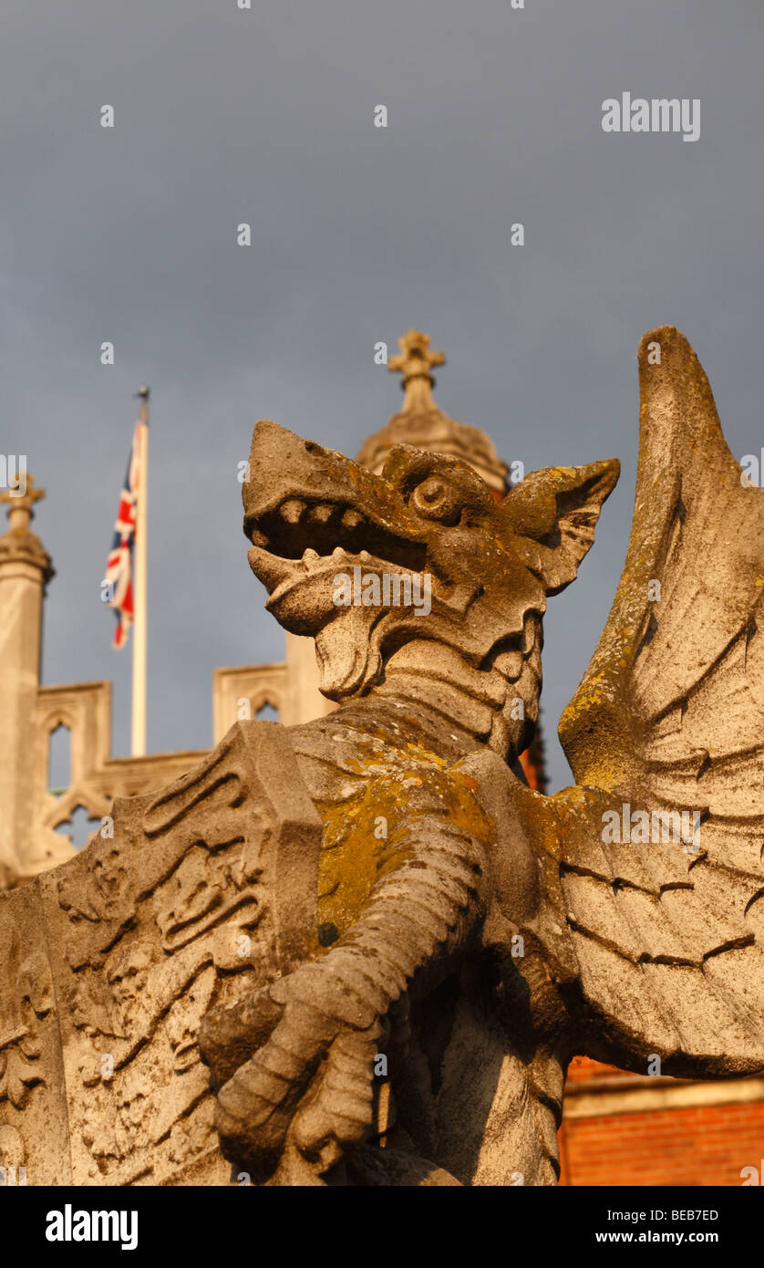 Avec l'Union flag derrière, un gros plan d'une statue de dragon à l'entrée principale de l'établissement Hampton Court Palace, Surrey, UK Banque D'Images