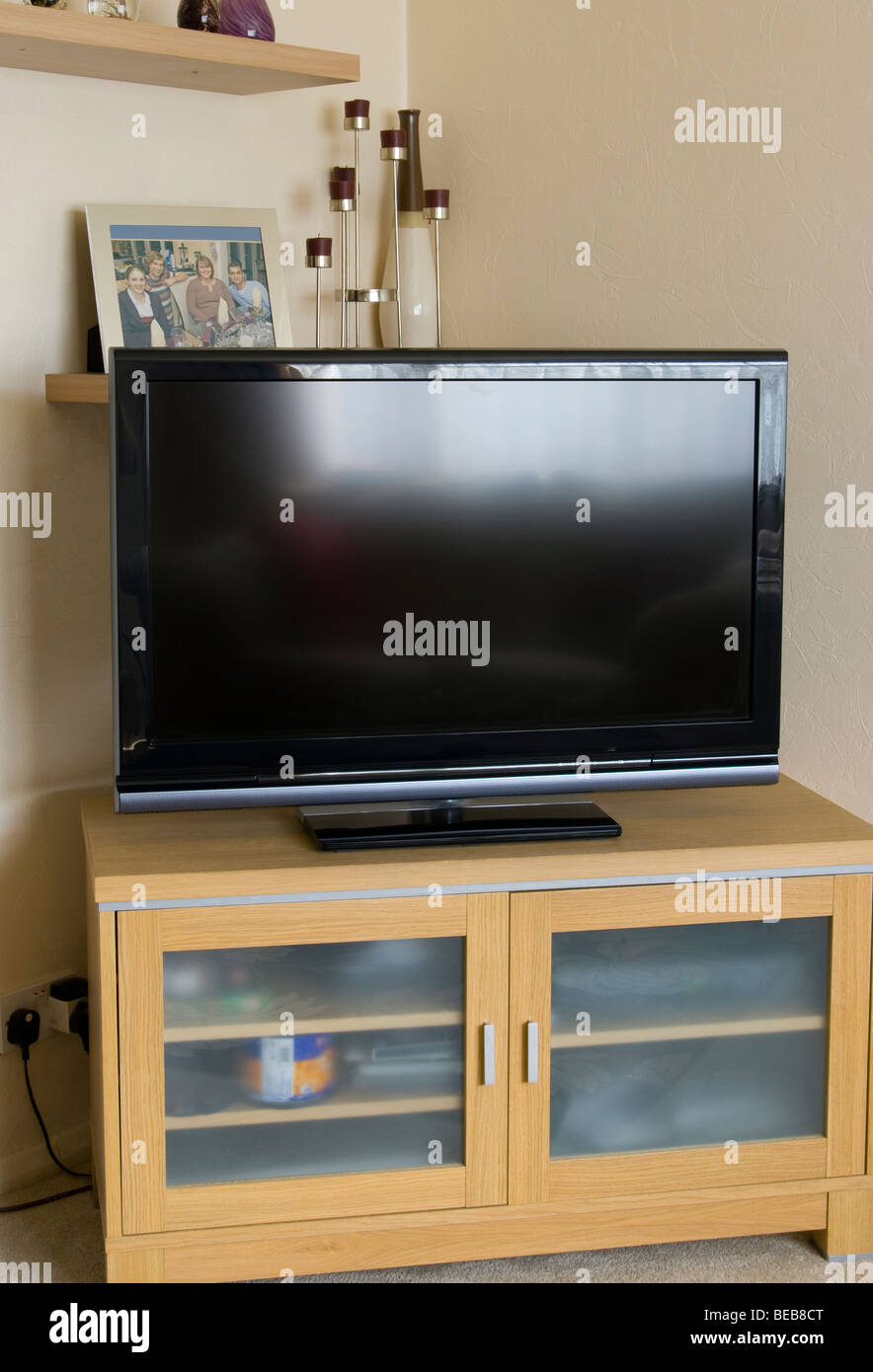 Une télévision écran plat dans le coin d'une salle de séjour sur une  armoire en bois et verre Photo Stock - Alamy