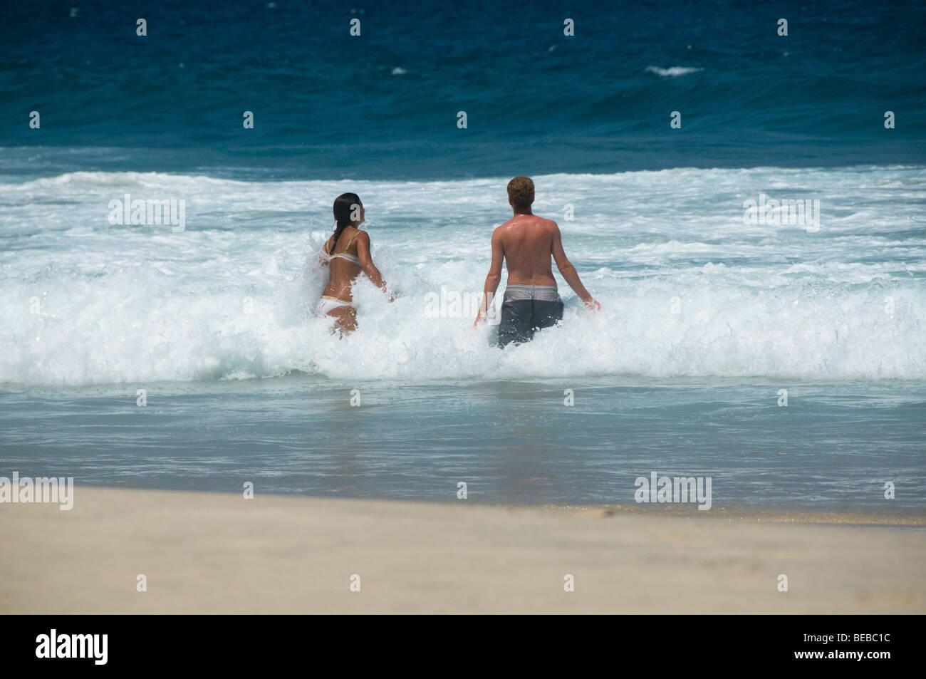 Les touristes appréciant les vagues à la plage à Bali Indonésie Banque D'Images