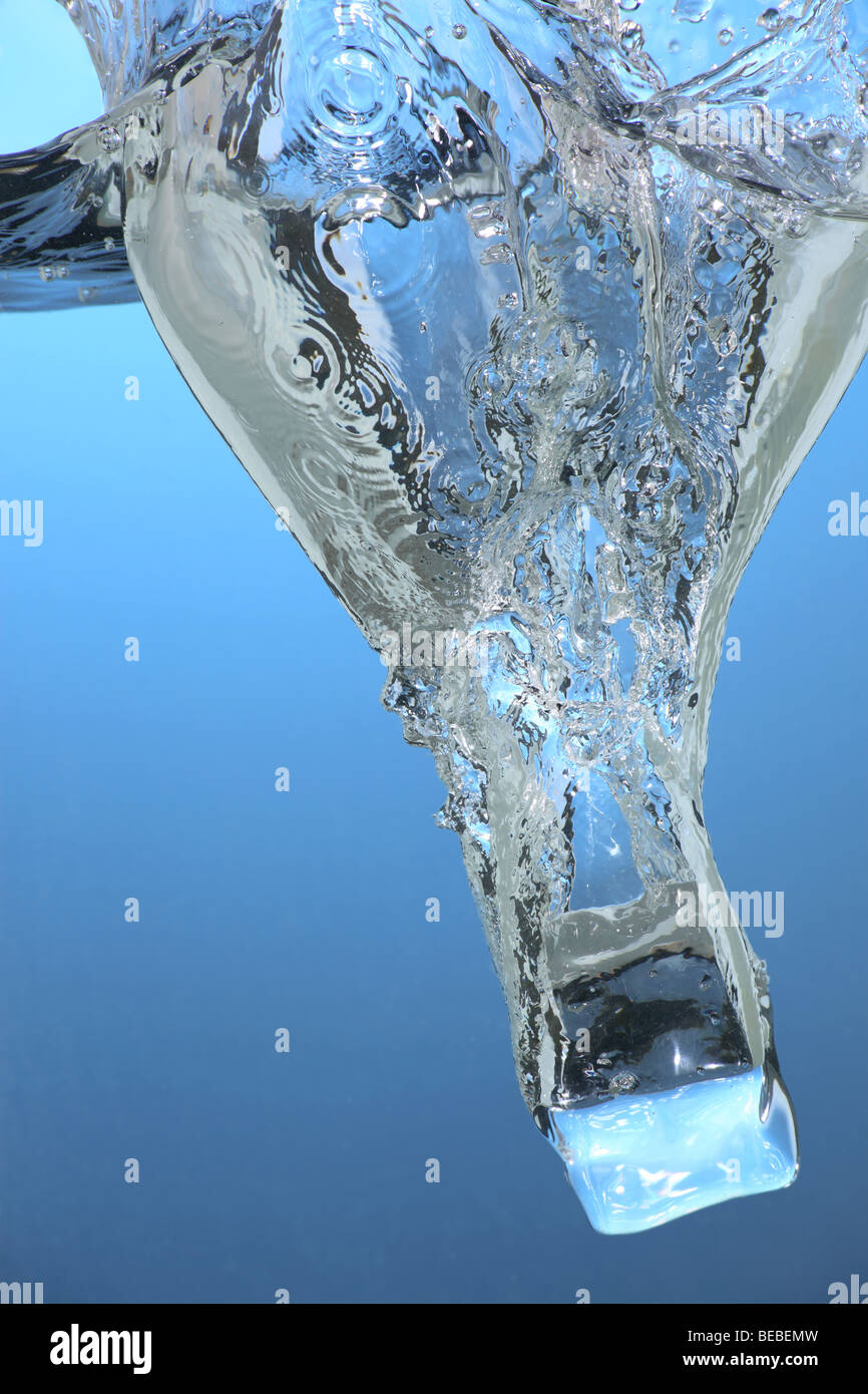 Un cube de glace tomber à l'eau Banque D'Images