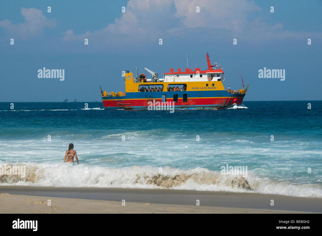 Les vagues touristiques bénéficiant comme un ferry va par à Bali Indonésie Banque D'Images