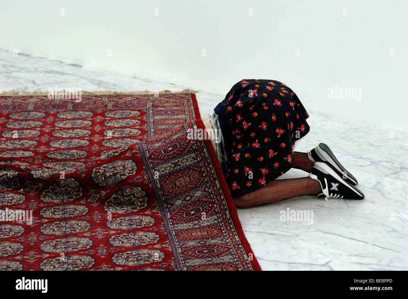 Femme à effectuer des travaux ménagers à genoux avec la tête sous l'installation de tapis l'art au Musée d'Art Moderne ou Marseille Marseille France Banque D'Images