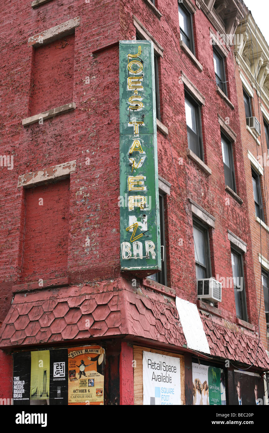 Vieille enseigne au néon d'un bar disparu depuis longtemps dans un immeuble en brique délabrée sur la 10e Avenue à New York City quartier de Chelsea Banque D'Images