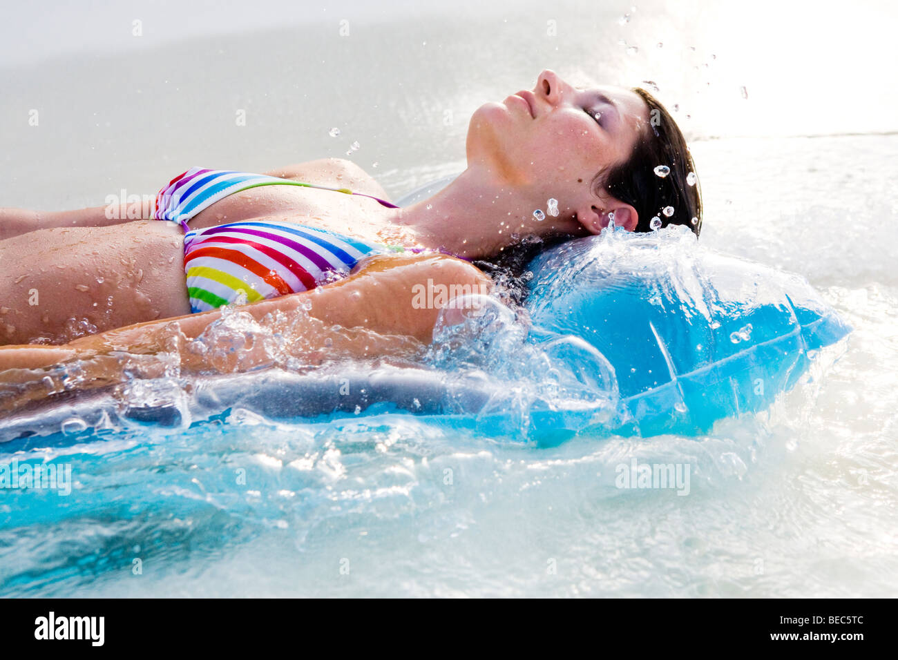 Une jeune femme se détend sur un lilo dans l'océan Banque D'Images