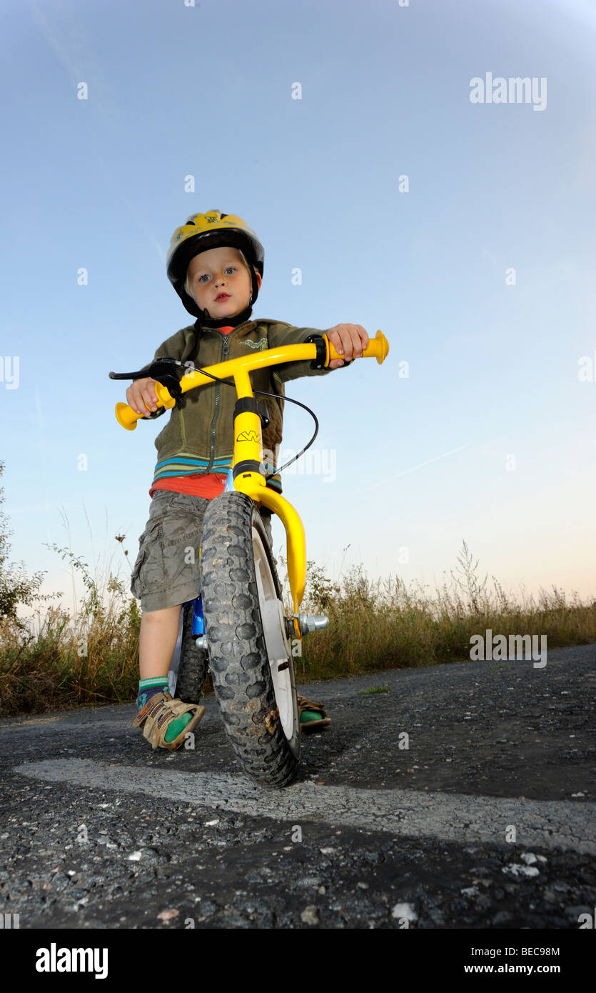 Garçon enfant randonnée à vélo à travers une forêt en vélo avec casque de vélo Banque D'Images