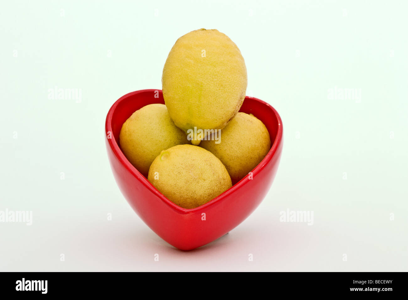 En forme de coeur rouge dur rempli de limes clés jaune mûr Banque D'Images