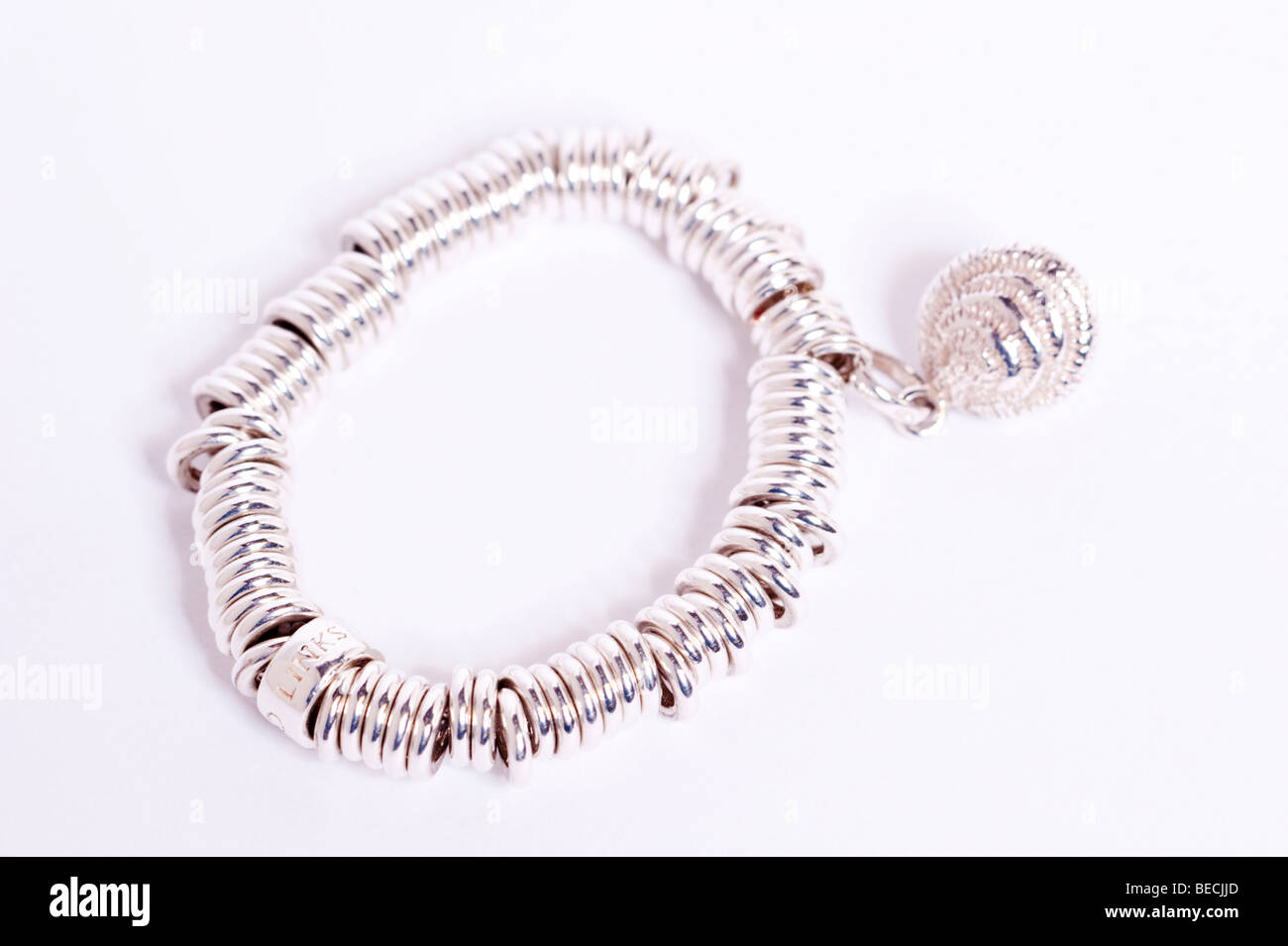 A womans Silver Links of London sweetie bracelet charme sur un fond blanc Banque D'Images