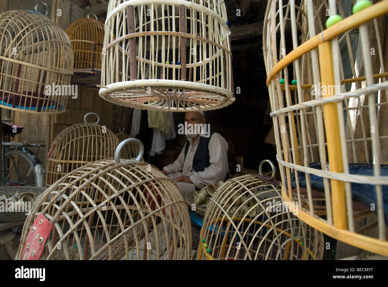 Kaboul, Afghanistan. Marché aux oiseaux. Des cages à vendre l'homme assis sur le sol, en attente pour les clients Banque D'Images
