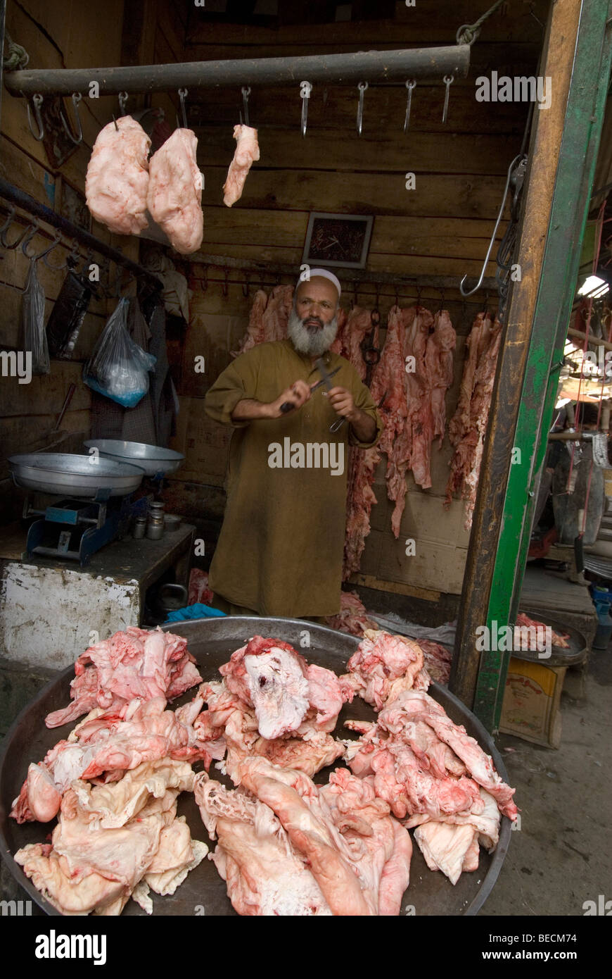 L'Afghanistan, Kaboul. Marché Central. Boucher avec de la viande, son couteau d'affûtage. Banque D'Images