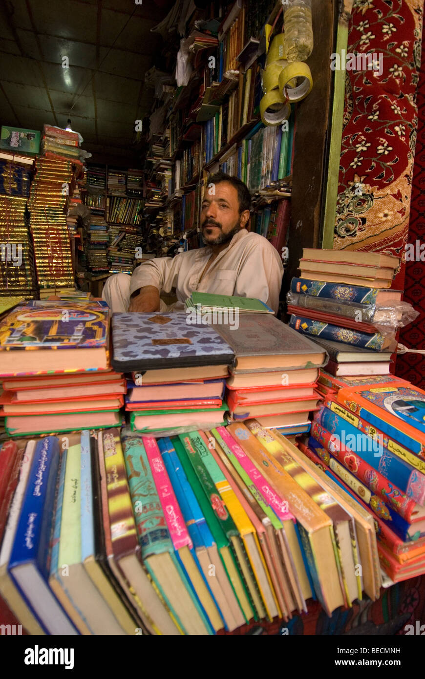 L'Afghanistan, Kaboul. Marché Central. Bookseller assis à son étal sur le marché. Banque D'Images