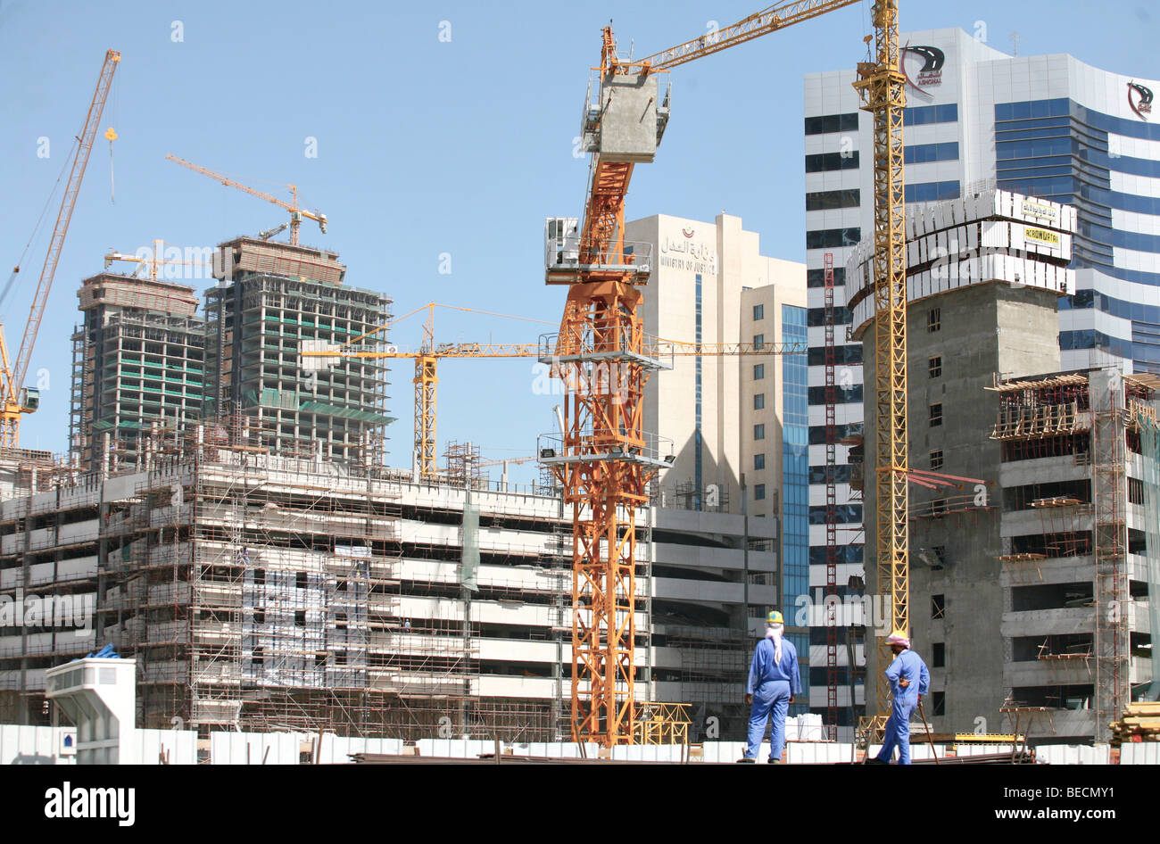 Deux ouvriers asiatiques donnent sur la zone de construction de grande hauteur dans le nouveau quartier de Doha, au Qatar, en 2007. Banque D'Images