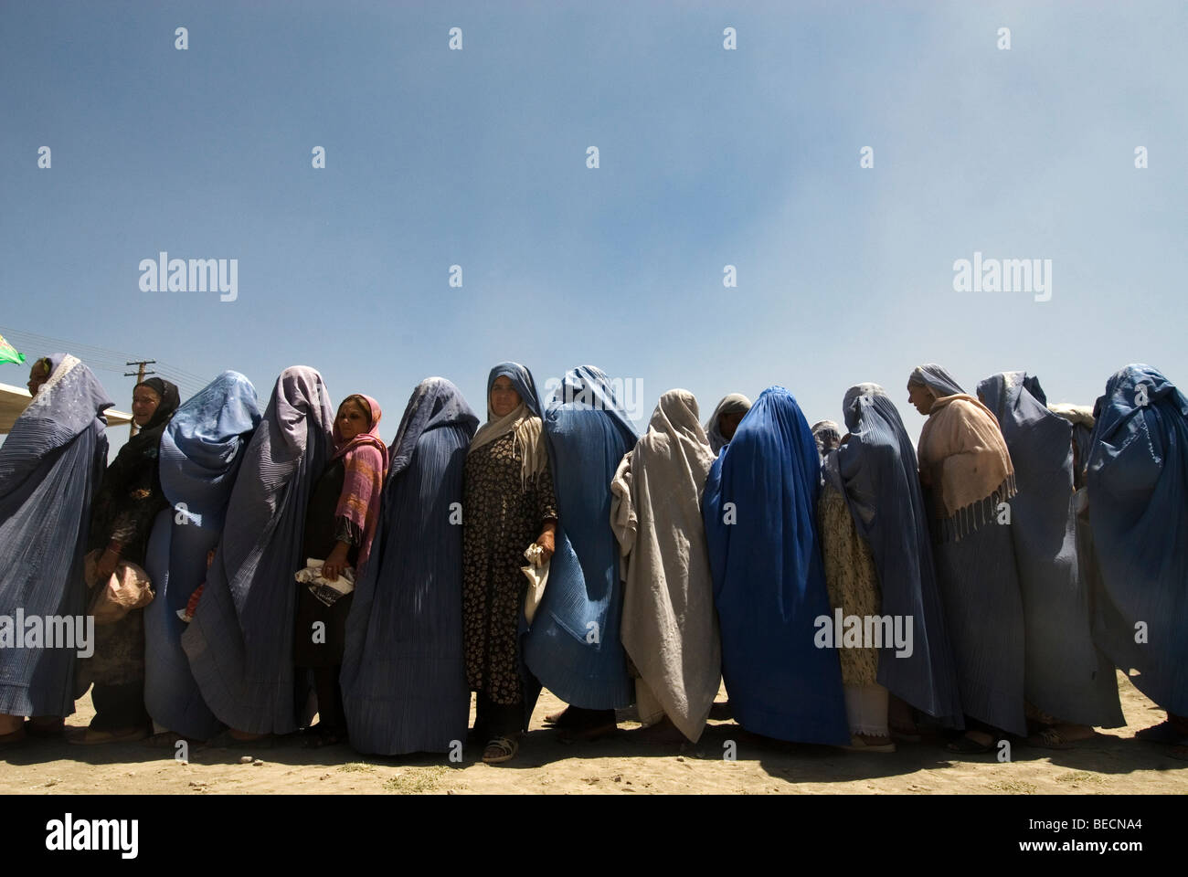 Kaboul, Afghanistan Les femmes portant des burkhas attendre la distribution alimentaire . Banque D'Images