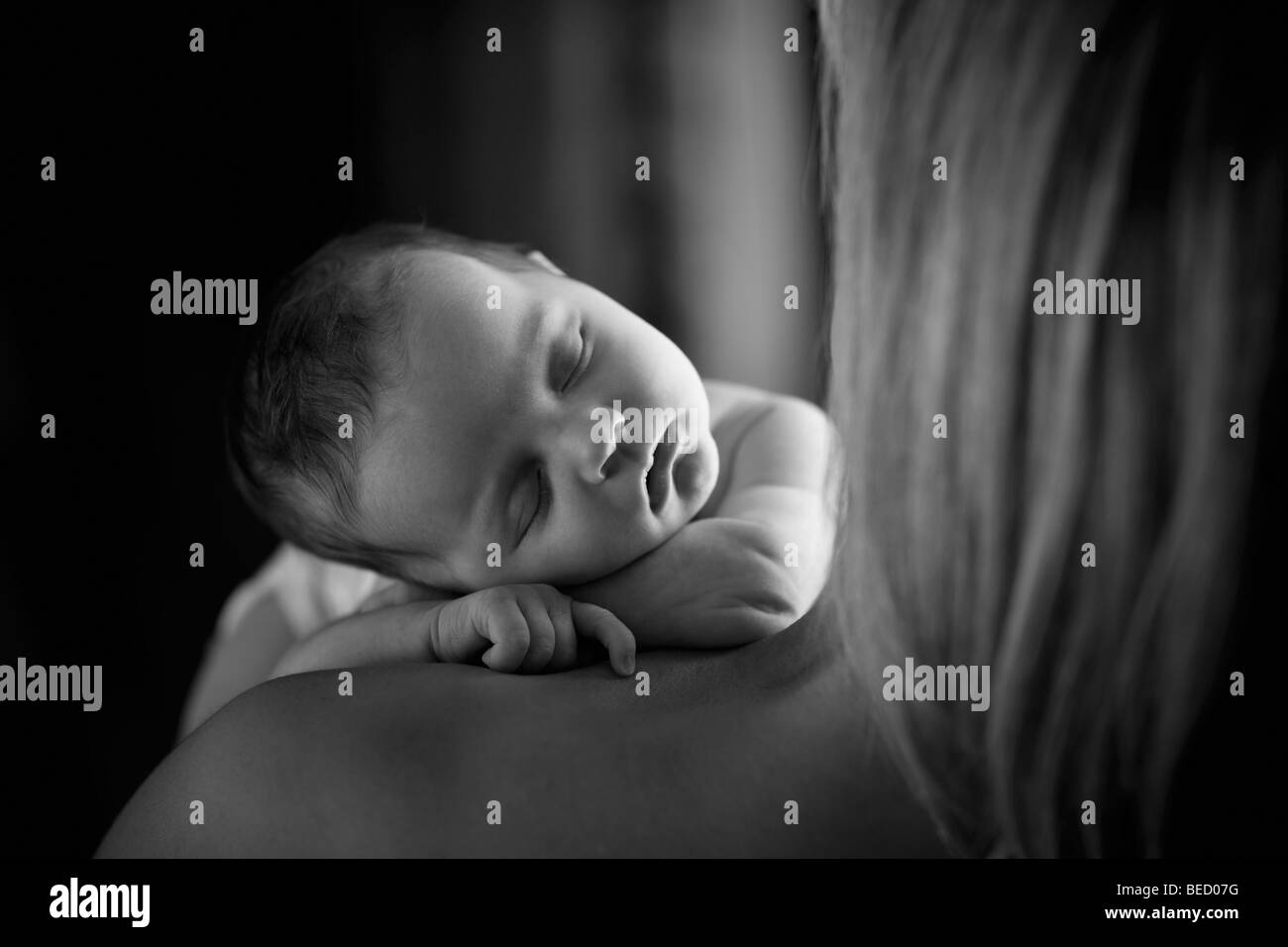 Bébé garçon endormi sur l'épaule de sa mère Banque D'Images