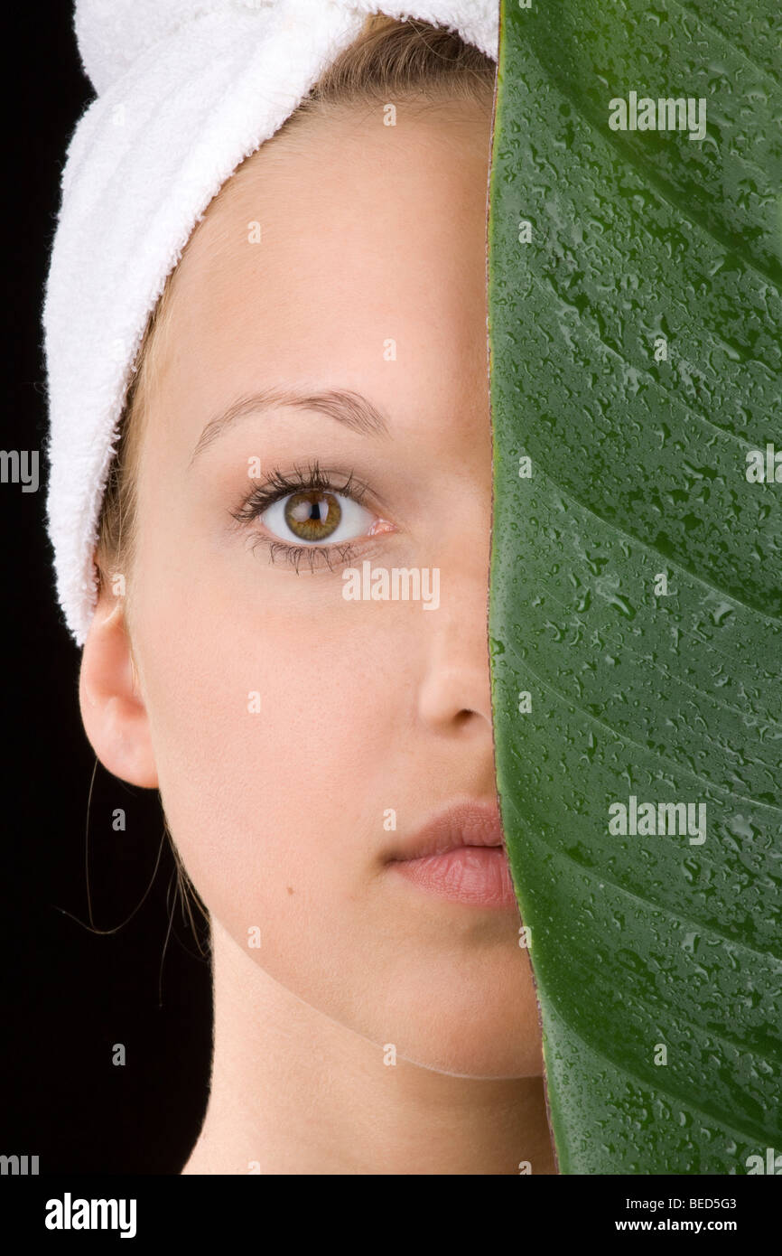Jeune femme, de l'humidité et la peau sensible, couverts de feuilles gouttes Banque D'Images