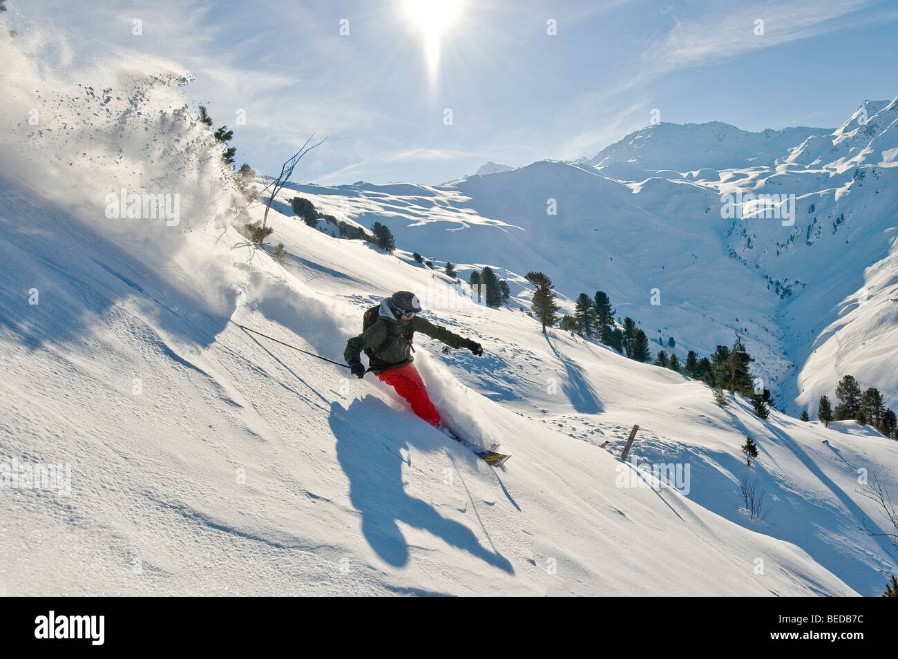 La neige profonde, skieur freerider, dans la neige profonde avec vue panoramique sur les Alpes et le soleil Banque D'Images
