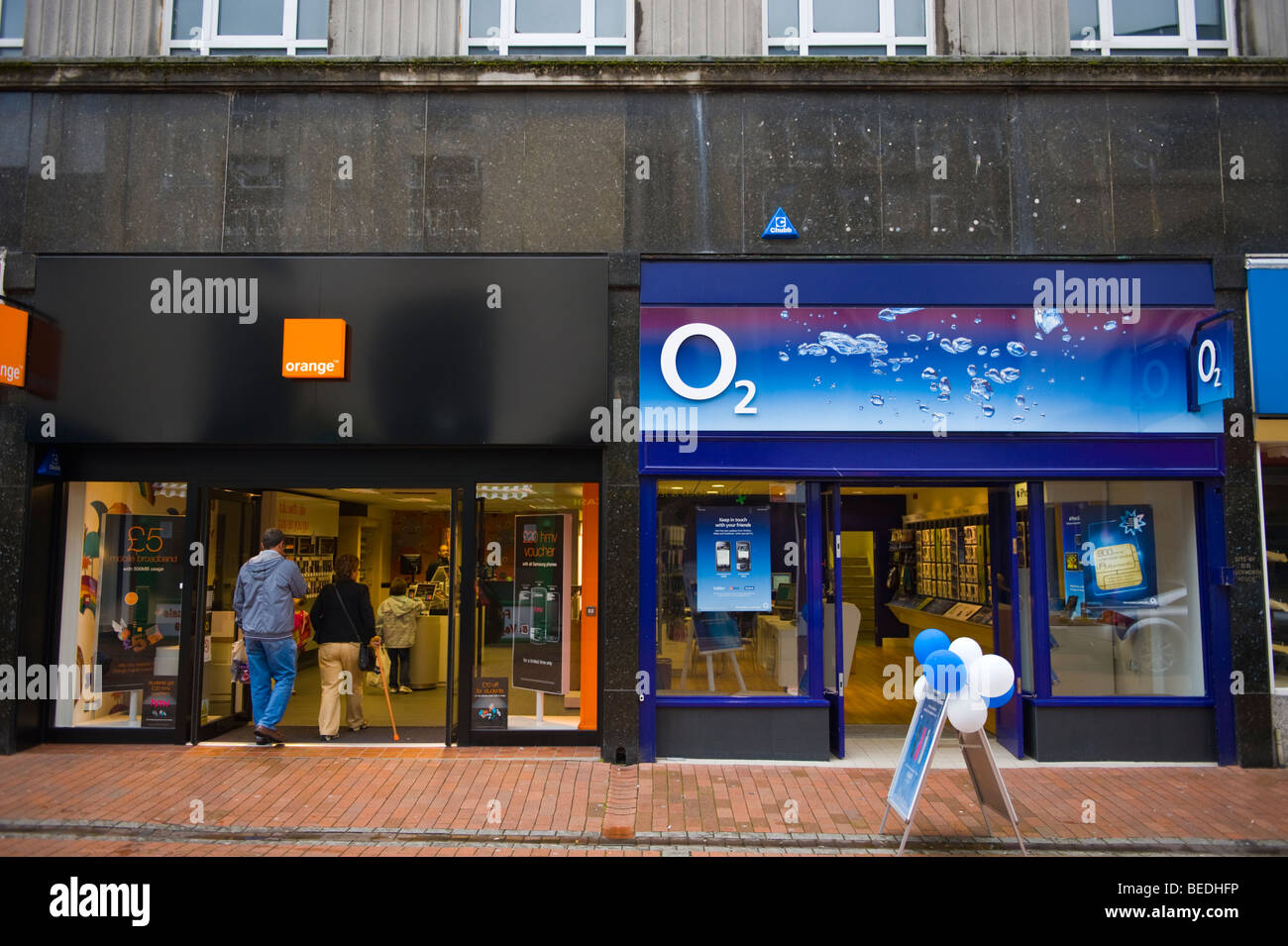 Orange et O2 mobile phone boutiques à côté de l'autre sur high street, dans le sud du Pays de Galles UK Neath Banque D'Images