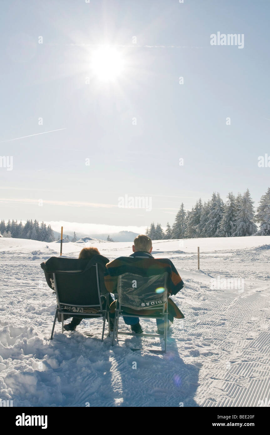 Couple enjoying winter sun, paysage d'hiver Banque D'Images