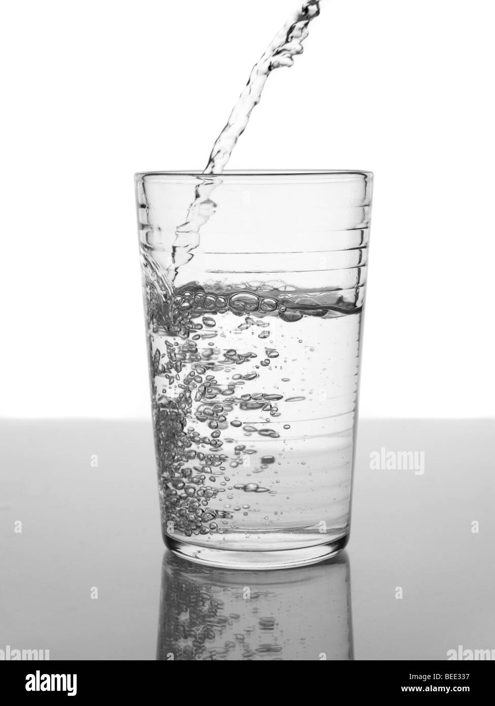 On verse de l'eau dans un verre. Banque D'Images