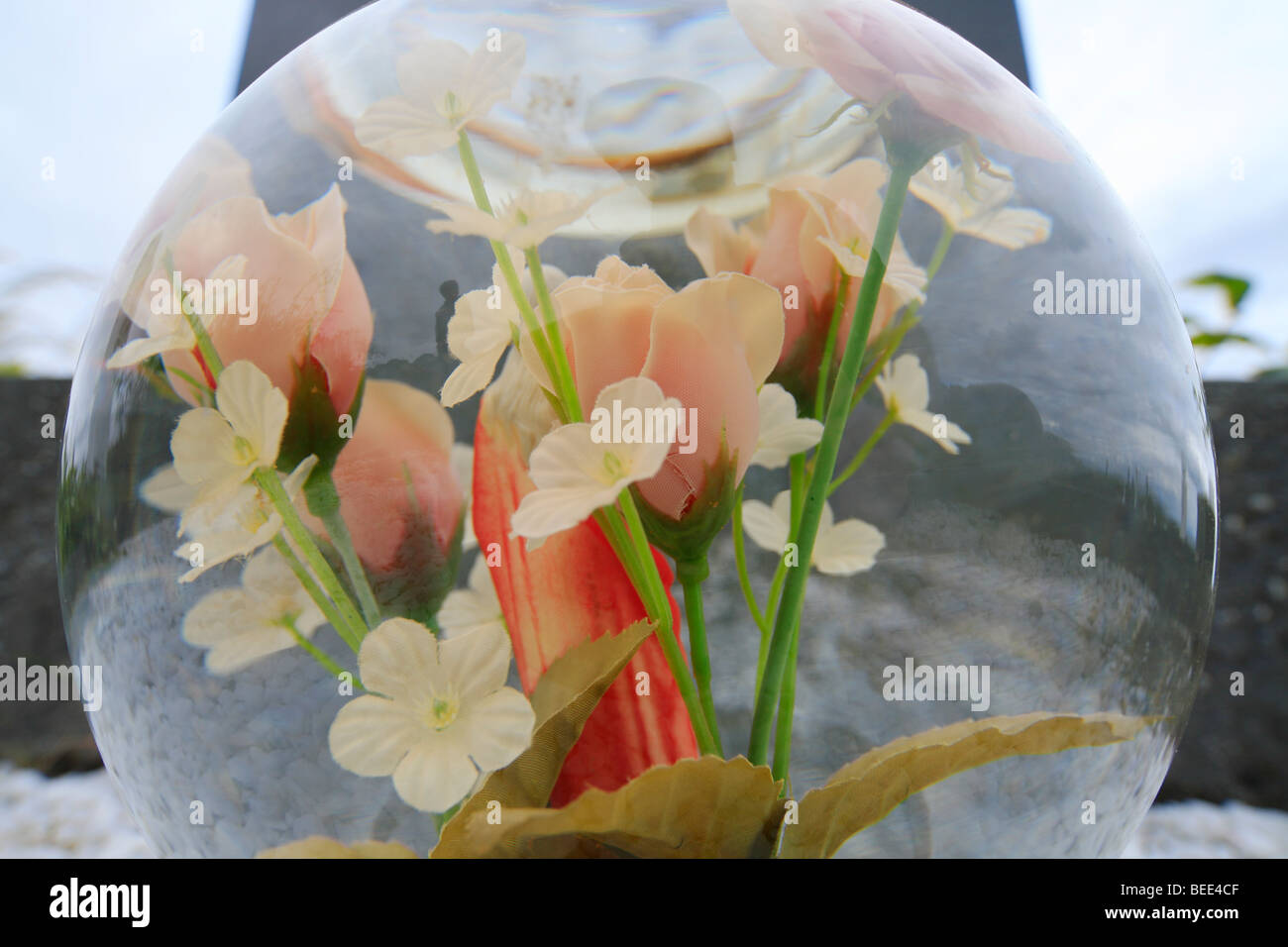 Fleurs en plastique à l'intérieur d'une boule de cristal comme décoration grave au cimetière dans Cloonluane, Renvyle, Irlande Banque D'Images