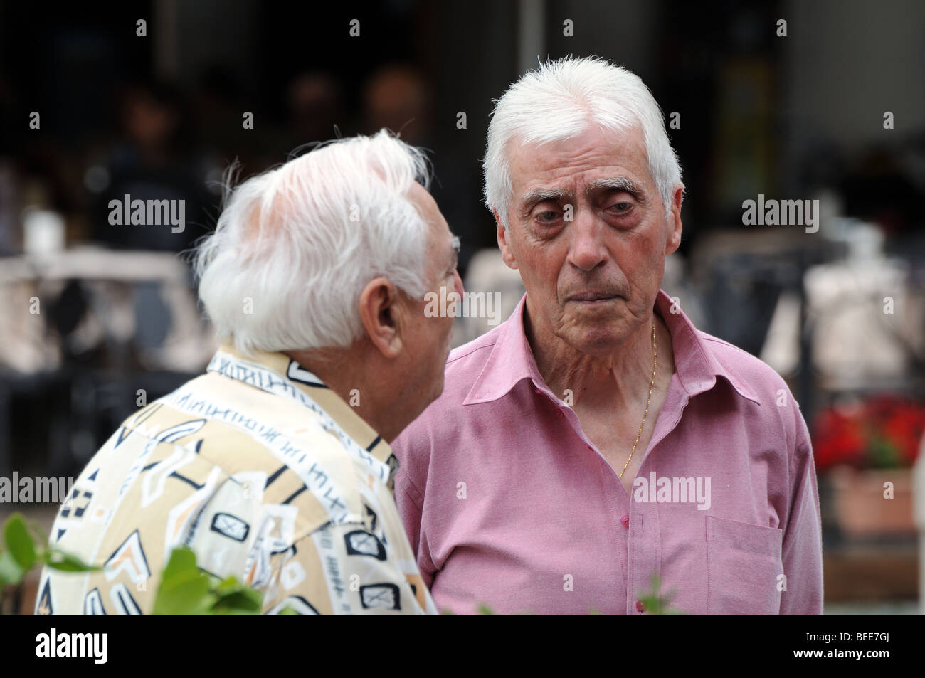 Deux personnes âgées vieux hommes retraités réunion pour matin chat dans la Piazza square de Vigevano Lombardia Italie Lombardie Banque D'Images