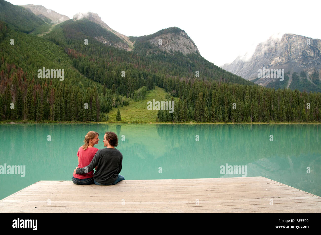 Young couple sitting on dock Banque D'Images