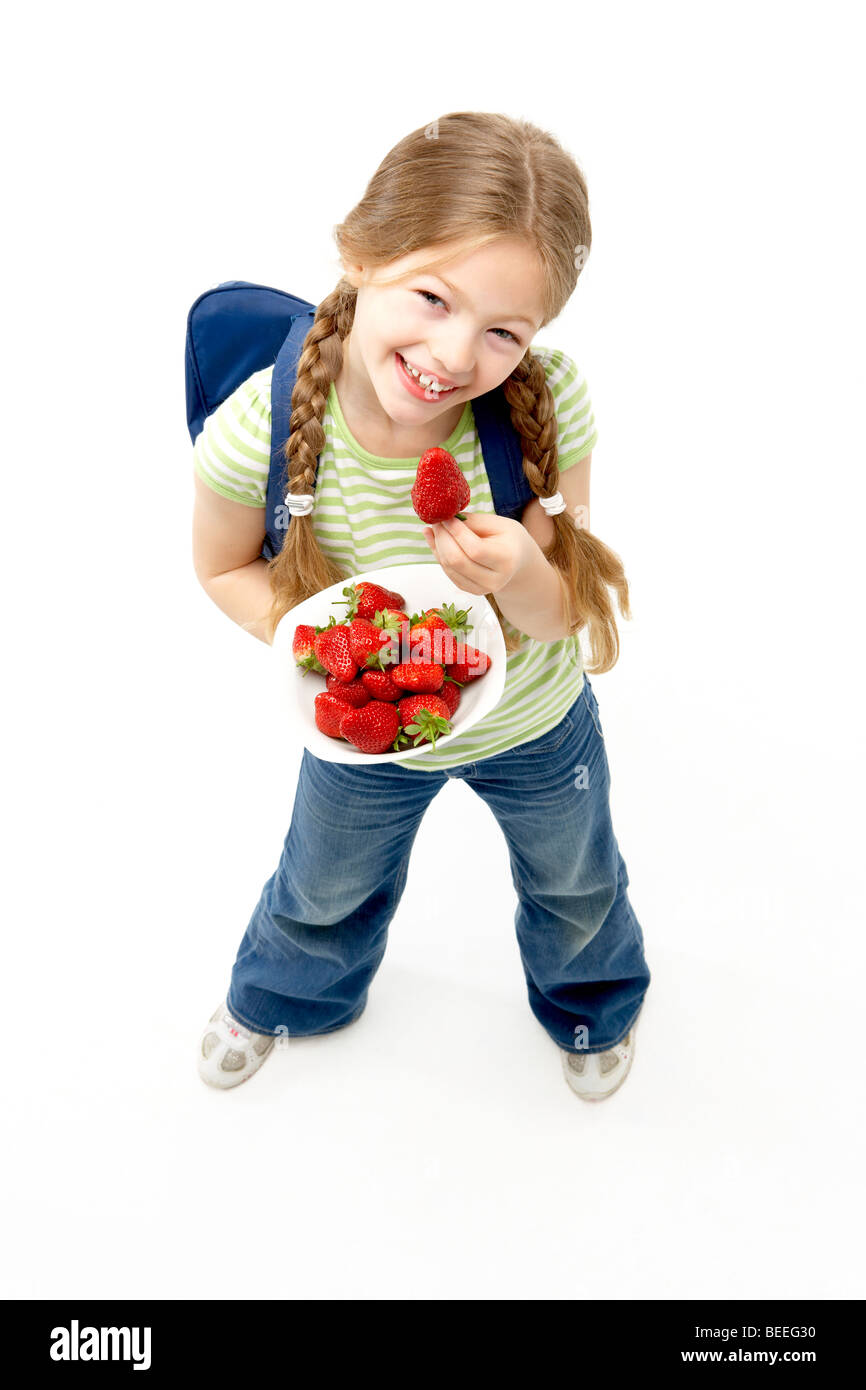 Studio Portrait of Smiling Girl Holding Bowl of Strawberries Banque D'Images