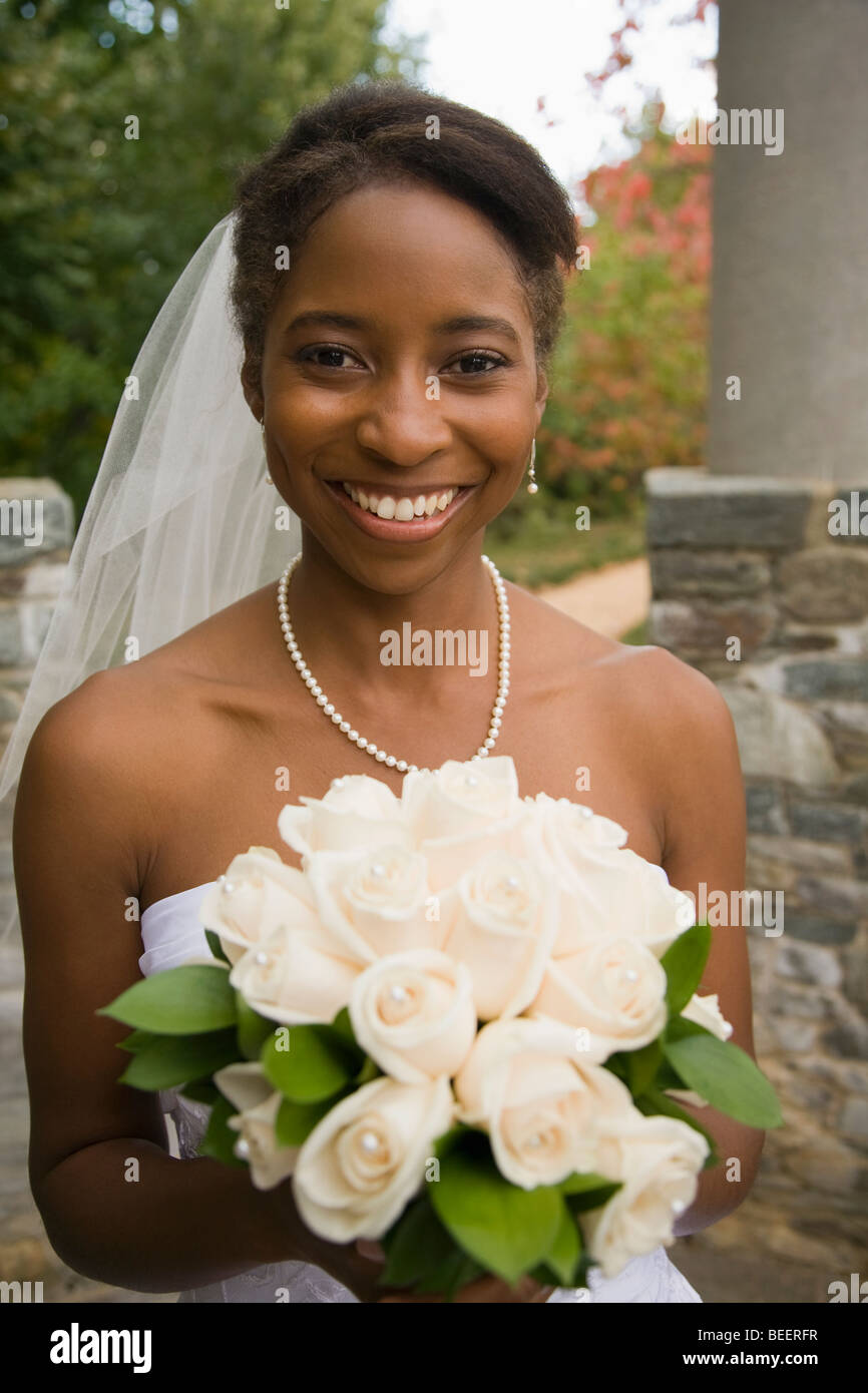 African bride holding bouquet rose et souriant Banque D'Images
