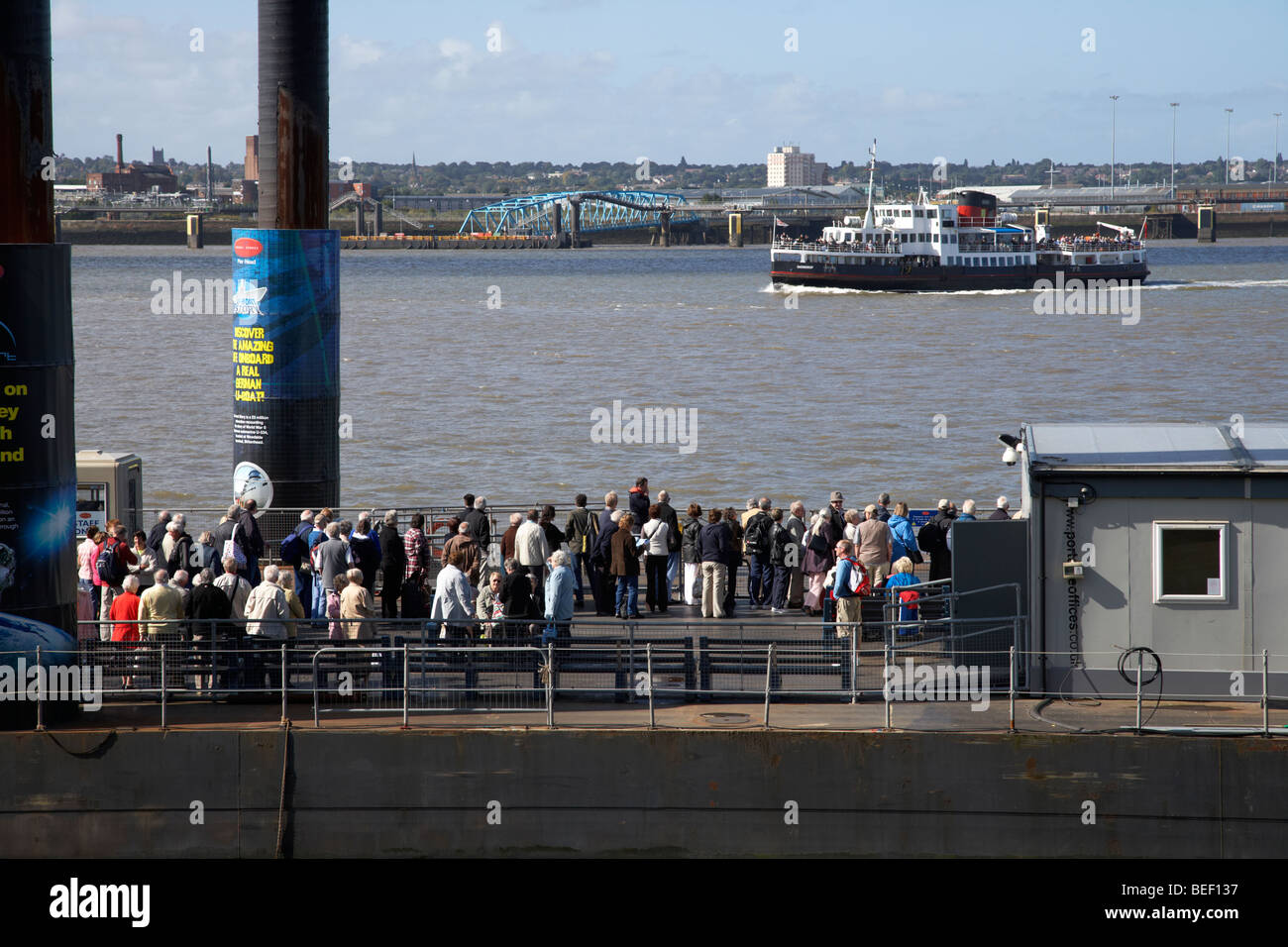Les touristes et les banlieusards queue à la pier head flottant ferry terminal en attente de la Mersey ferry sur la rivière Mersey Banque D'Images
