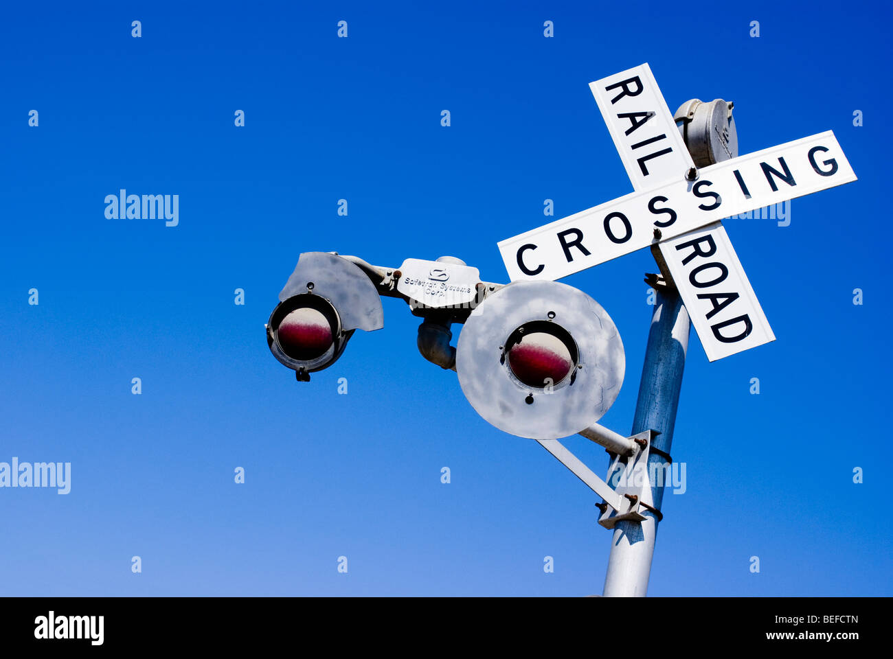 Un railroad crossing sign against a blue sky. Banque D'Images