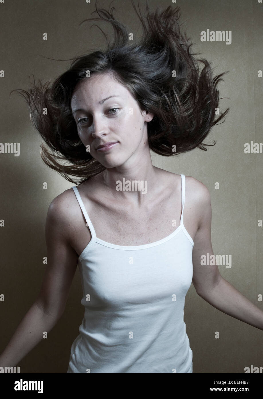 Studio portrait de jeune femme avec cheveux flottant dans l'air. Banque D'Images