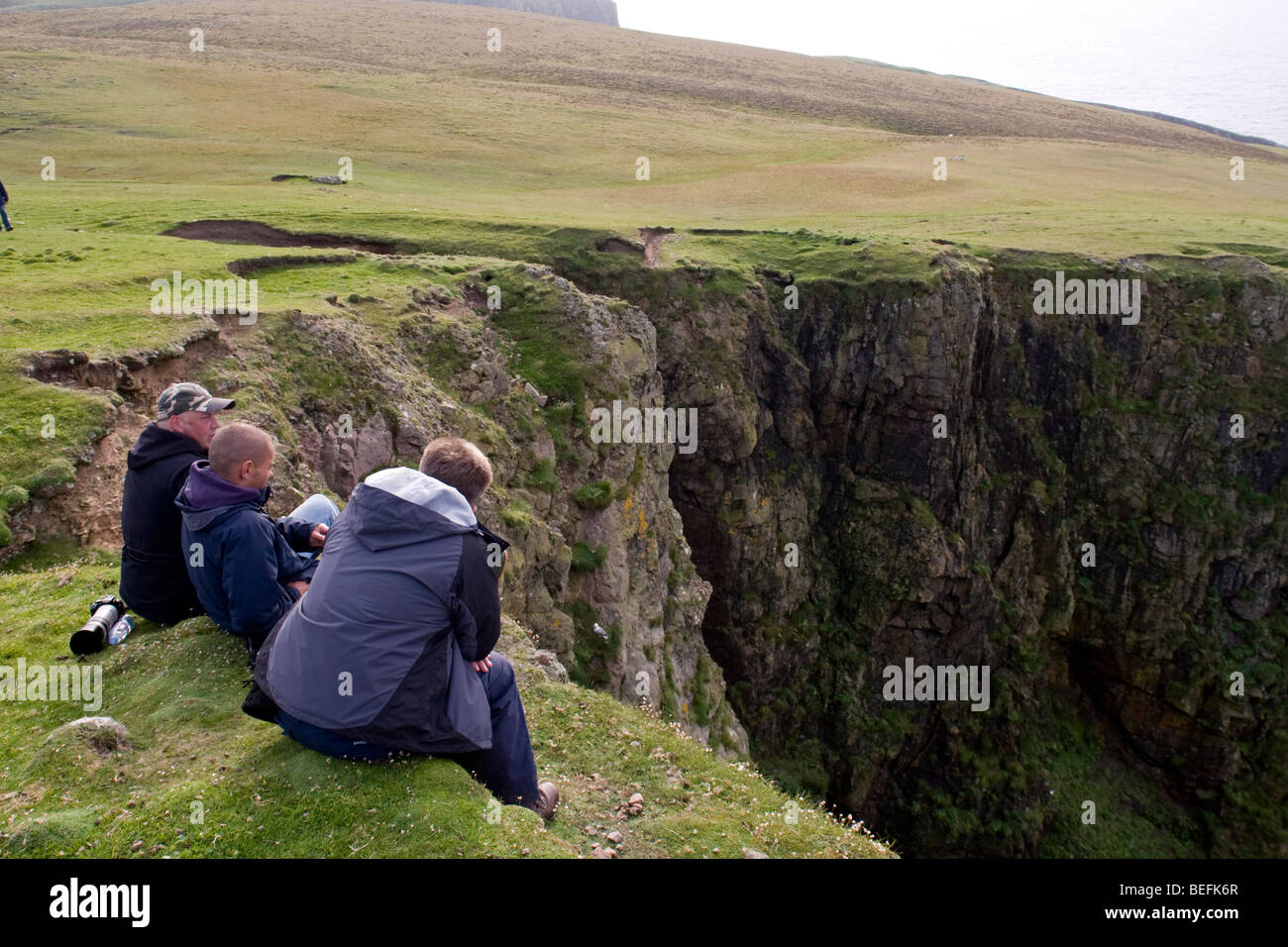 Les gens au bord de la falaise sur Fair Isle Shetland Banque D'Images