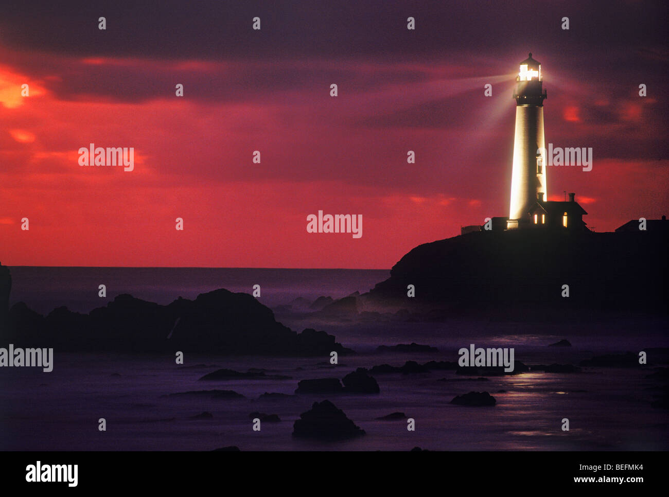 Pigeon Point Lighthouse dans l'ensemble de faisceau casting côte rocheuse et le coucher du soleil du ciel. Cette image n'est pas modifié de façon numérique - Il n'a pas été fait de la photo. Du vrai ! Banque D'Images