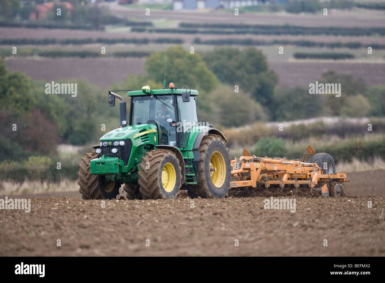 Tracteur John Deere en cultivant la terre prêt pour le forage Banque D'Images