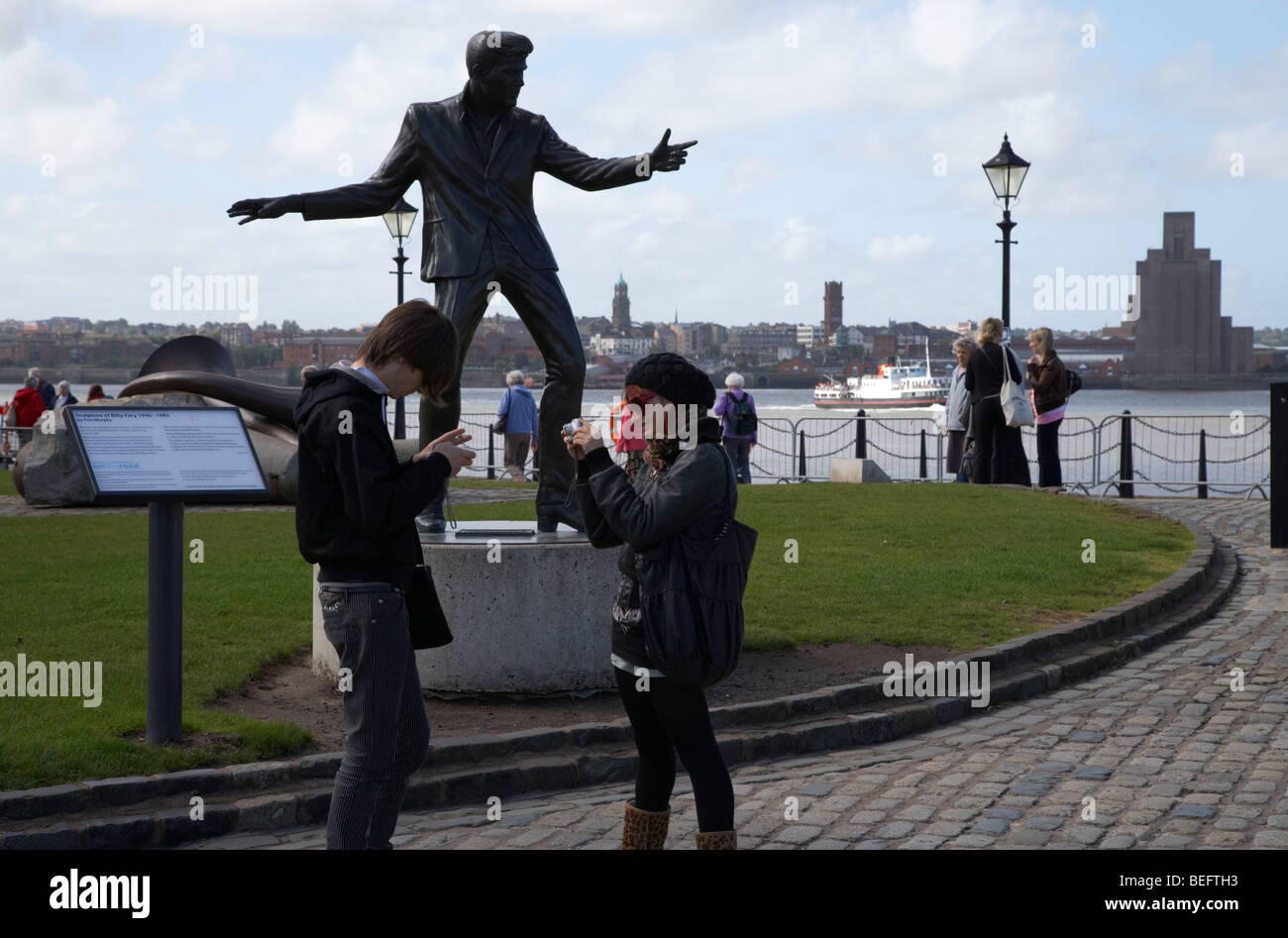Les touristes à la Billy Fury sculpture à l'Albert Dock Liverpool Merseyside England uk Banque D'Images