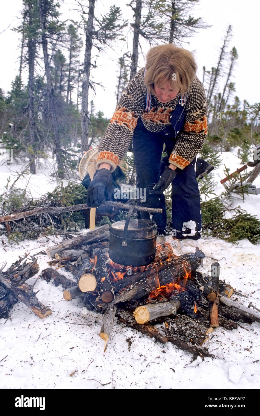 Femme a tendance feu en hiver lors d'une ébullition jusqu 'à long terme' (Terre-Neuve), pour un pique-nique. Banque D'Images