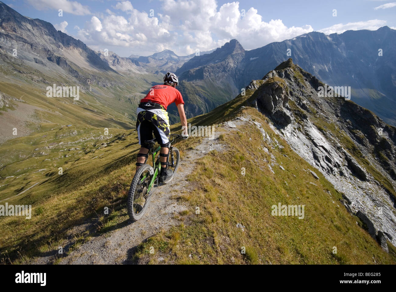 Un vélo de montagne monte un sentier sur une crête près de Les Arcs dans les Alpes françaises. Banque D'Images