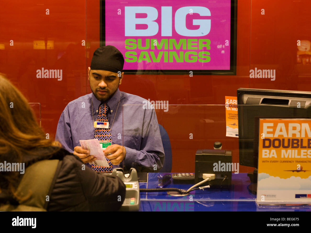 Bureau de change Travelex sert de monnaie assistant passager à l'aéroport d'Heathrow Terminal 5 Banque D'Images