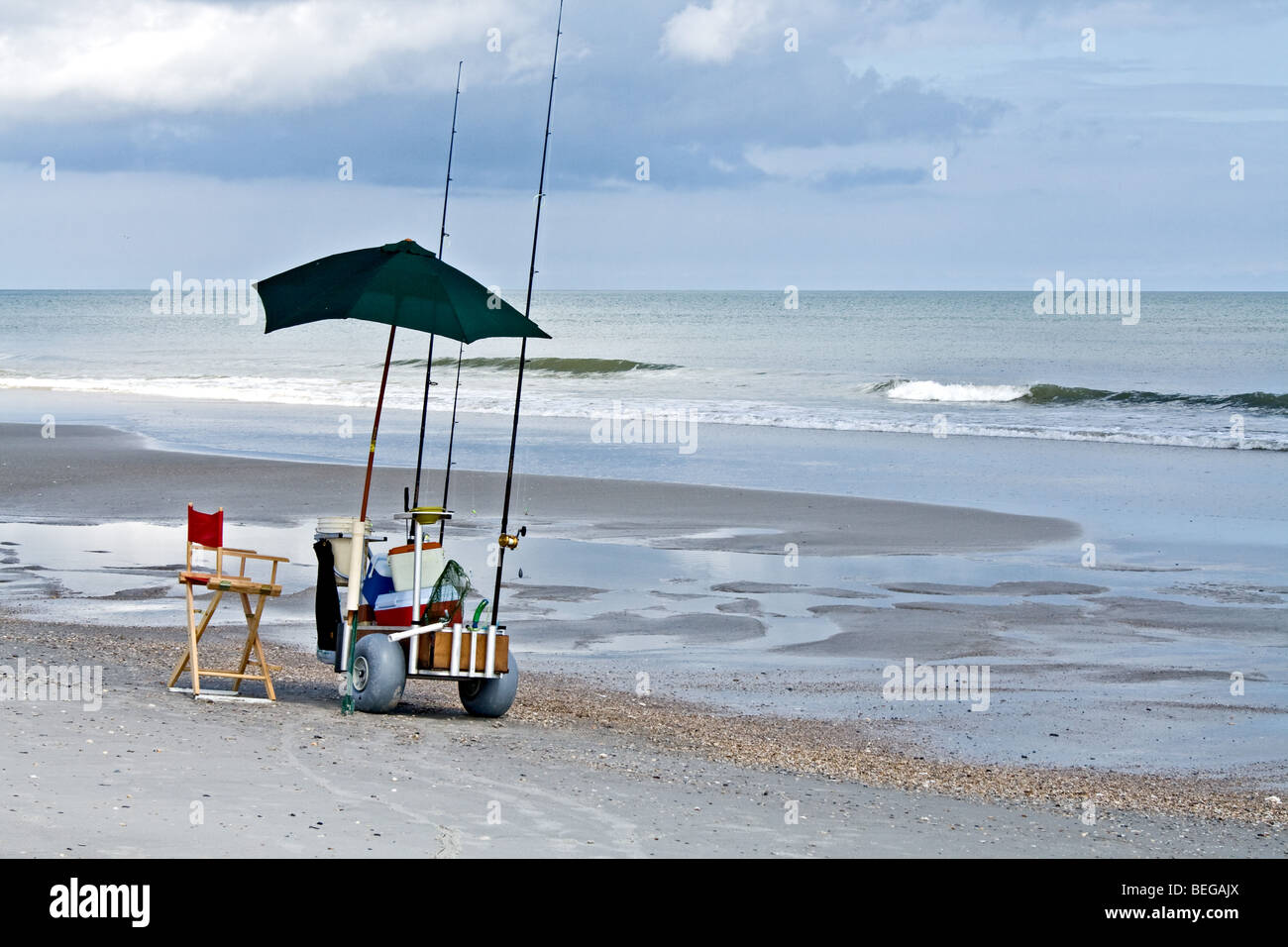 Les engins de pêche, parasol et glacière sur un chariot sur la plage de Jacksonville Beach, Floride Banque D'Images