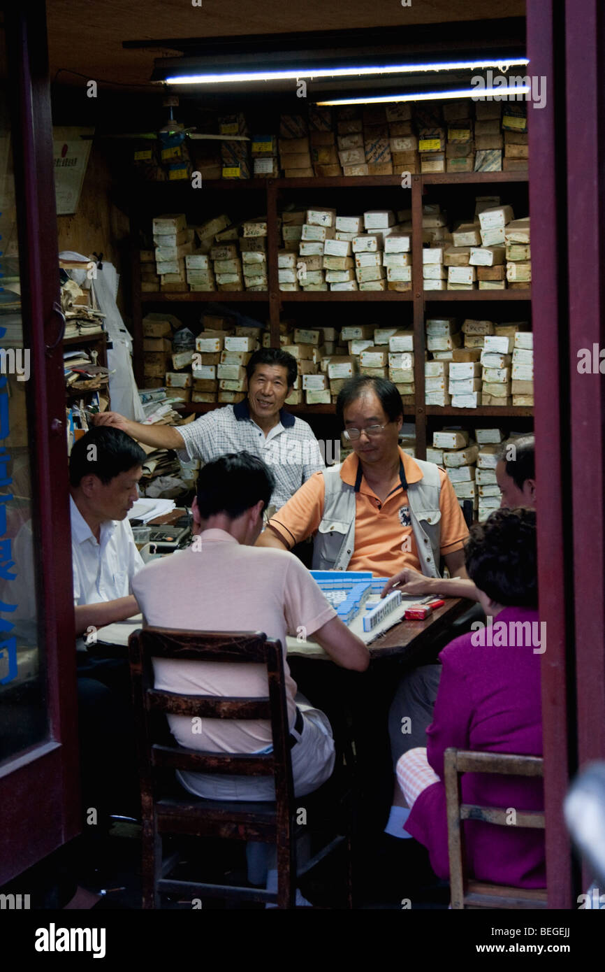 6 personnes jouant un jeu dans un petit magasin à Shanghai Chine Banque D'Images