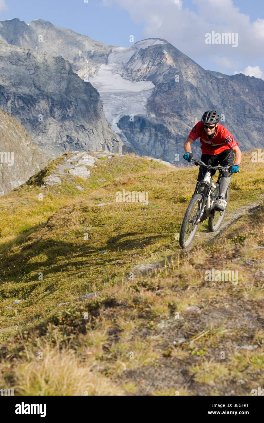 Un vélo de montagne monte un sentier singletrack dans Les Arcs dans les Alpes françaises. Banque D'Images