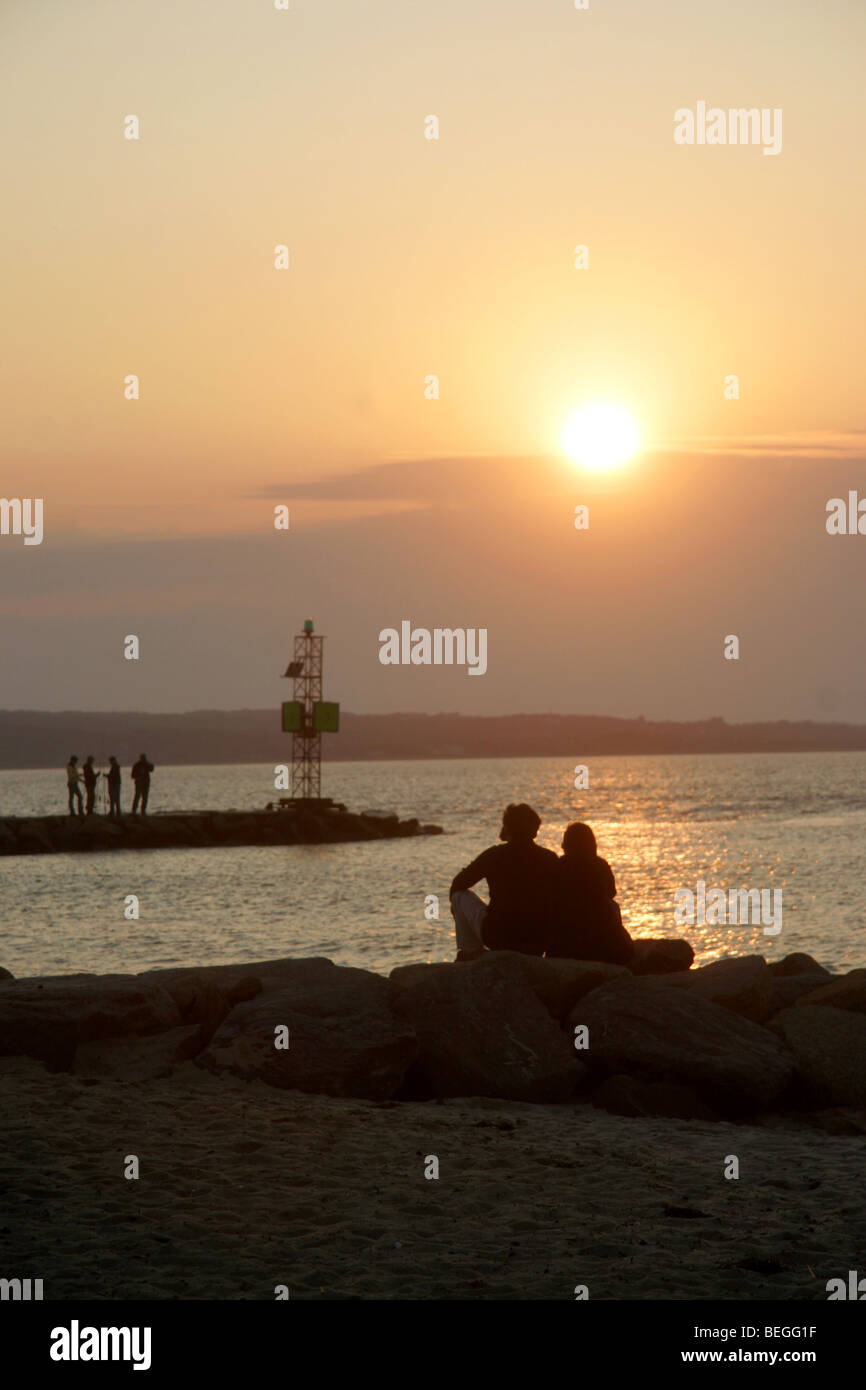 Couple en regardant le coucher du soleil sur la plage à Menemsha, Martha's Vineyard, Cape Cod, New England, Massachusetts, USA Banque D'Images