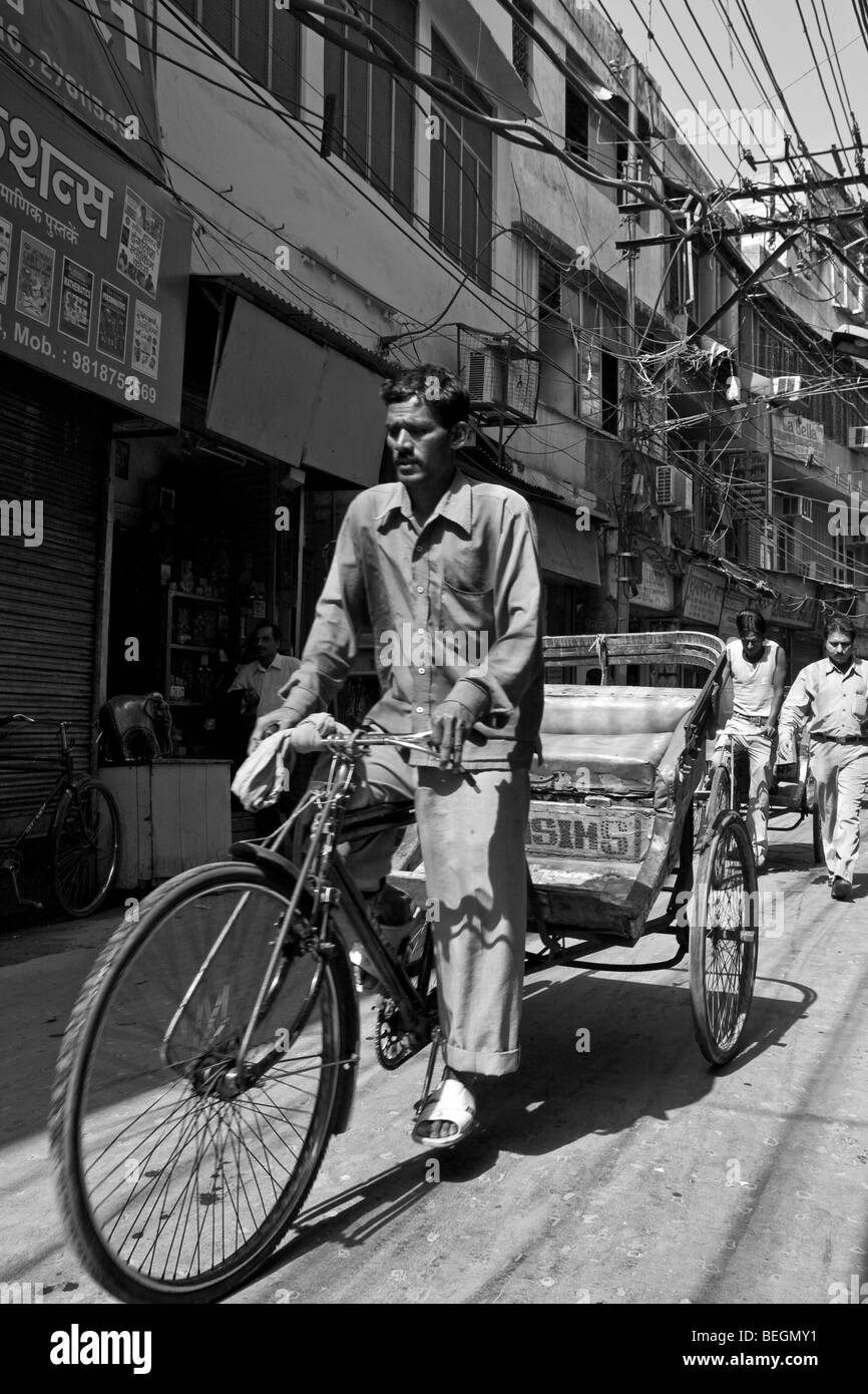 Rickshaw wallah Cycle qui exerce son art dans les rues de la vieille ville de Delhi, Inde Banque D'Images