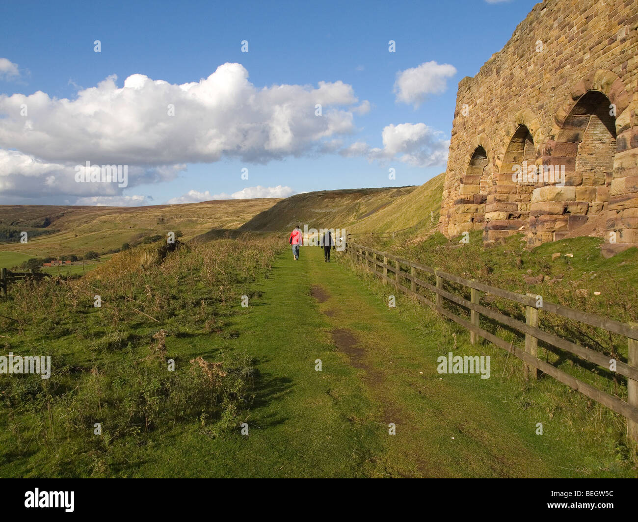 Un homme et une femme marcher leur chien labrador passé les ruines des fours à Rosedale mine est Banque D'Images