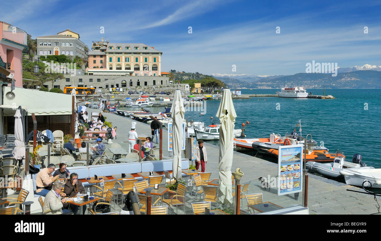 Les touristes profiter d'une après-midi de printemps précoce dans les restaurants de la promenade de Proto Venere, Ligurie, Italie. Banque D'Images