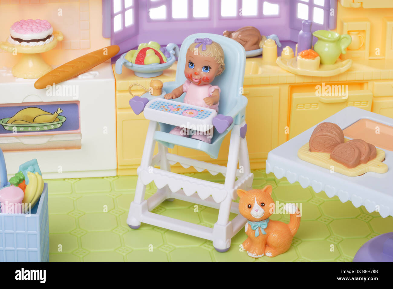 Jeune enfant poupée dans une chaise haute dans la cuisine Banque D'Images
