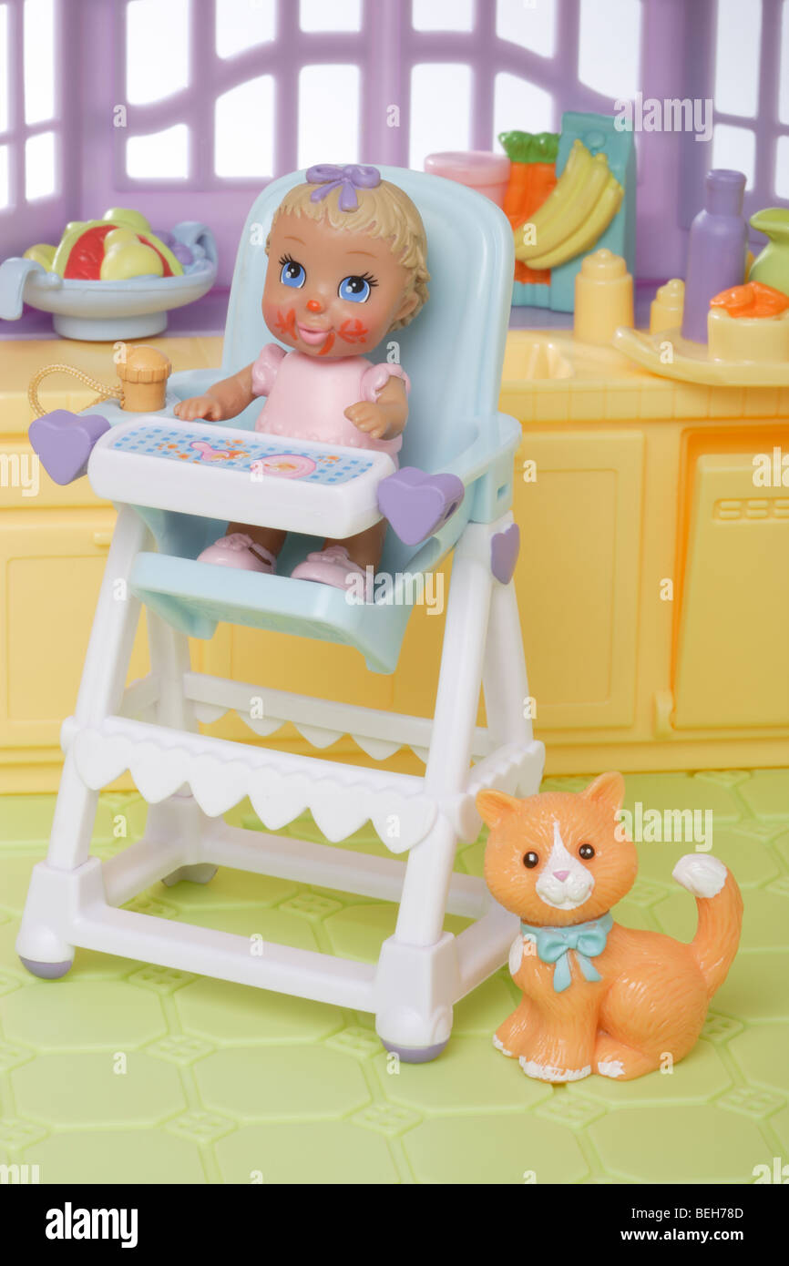 Jeune enfant sur une chaise haute de poupée Banque D'Images