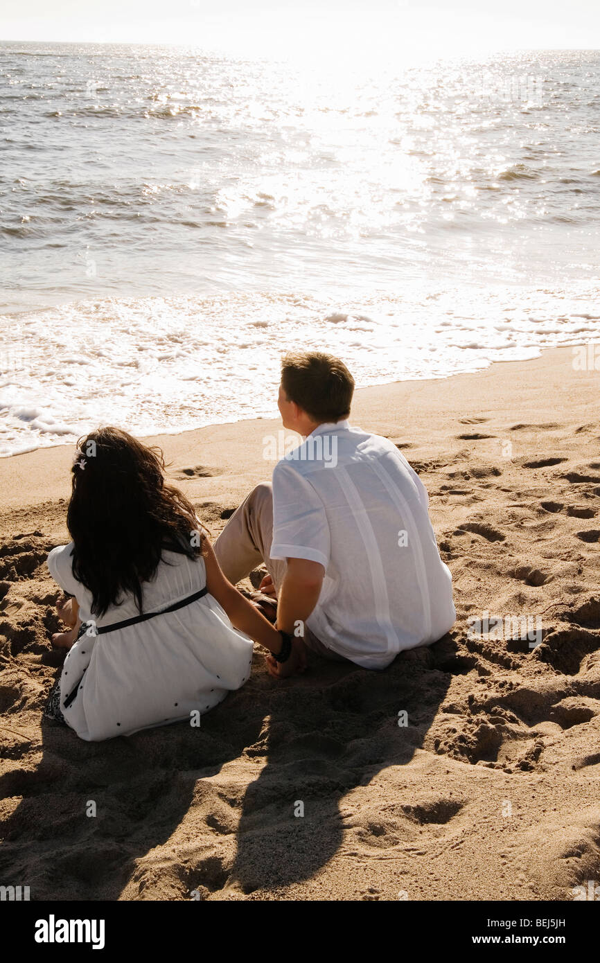 Vue arrière d'un couple assis sur la plage Banque D'Images
