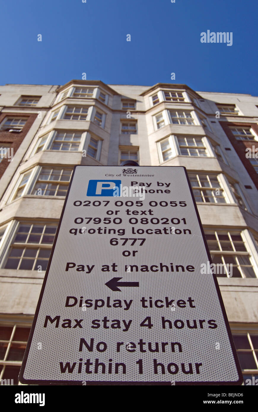 Payer et Afficher le panneau de signalisation à la réglementation locale sur le Queensway, Londres, Angleterre, avec bloc d'appartements en arrière-plan Banque D'Images